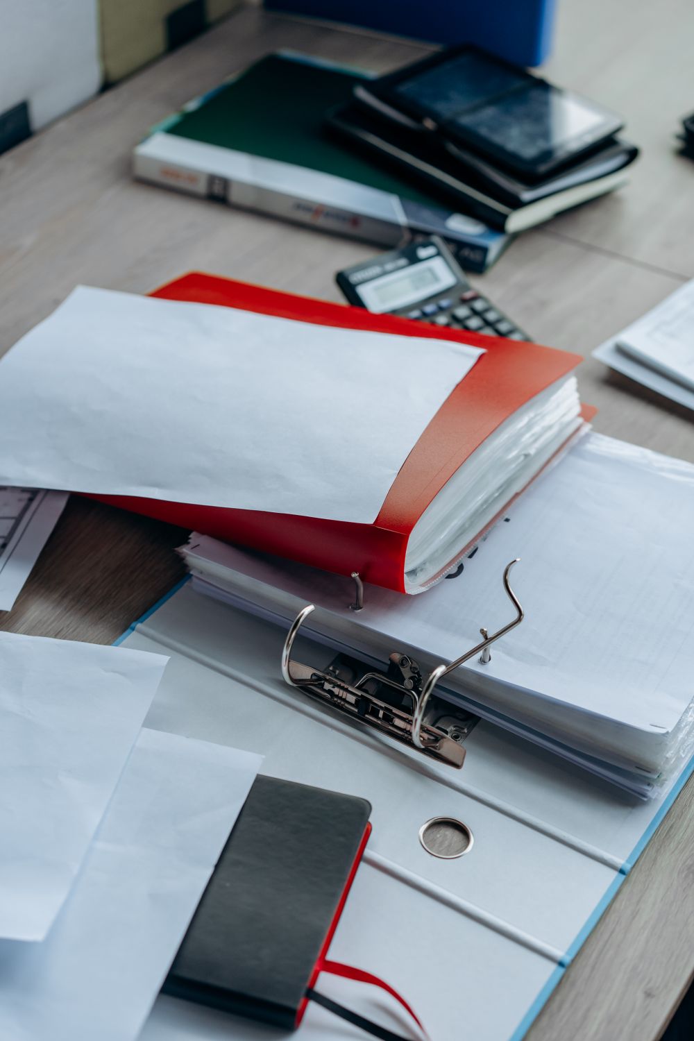Documentación técnica preventiva y archivadores sobre una mesa