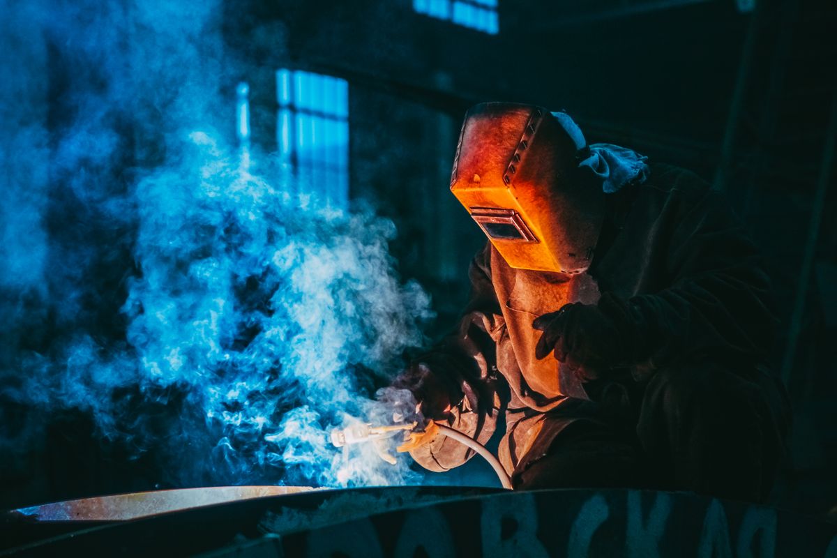 Trabajo de soldadura con emisión de humos en un entorno industrial